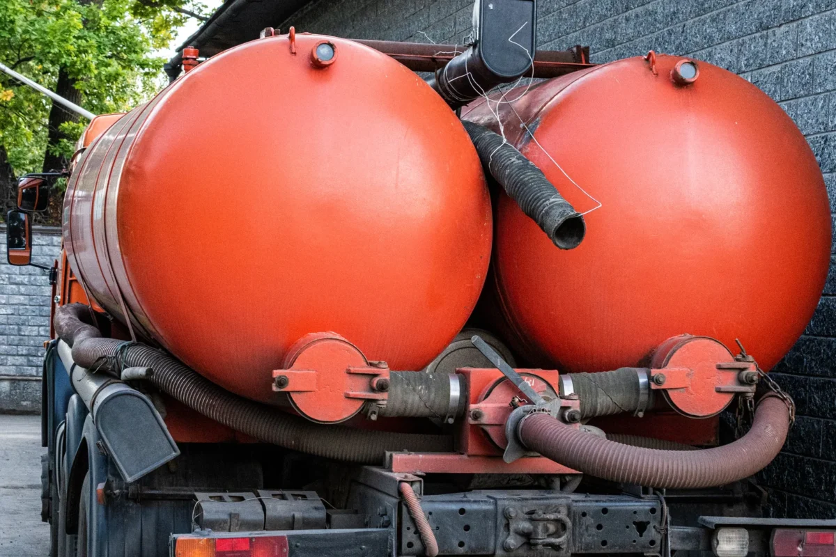 Rear view of an orange vacuum tanker with large collection tanks